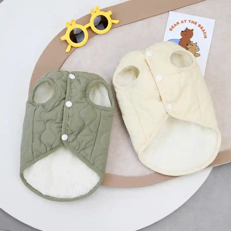 Green and beige dog vests displayed on a table