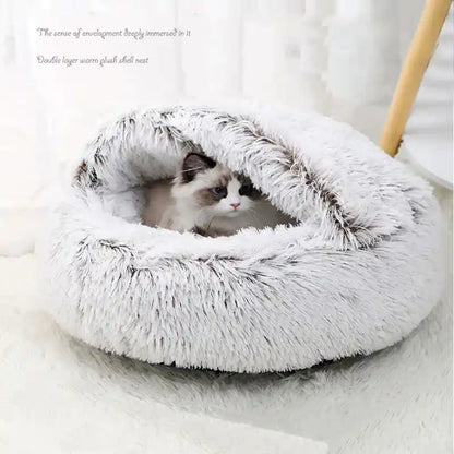 Cat nestled in gray plush winter bed, snug fit.