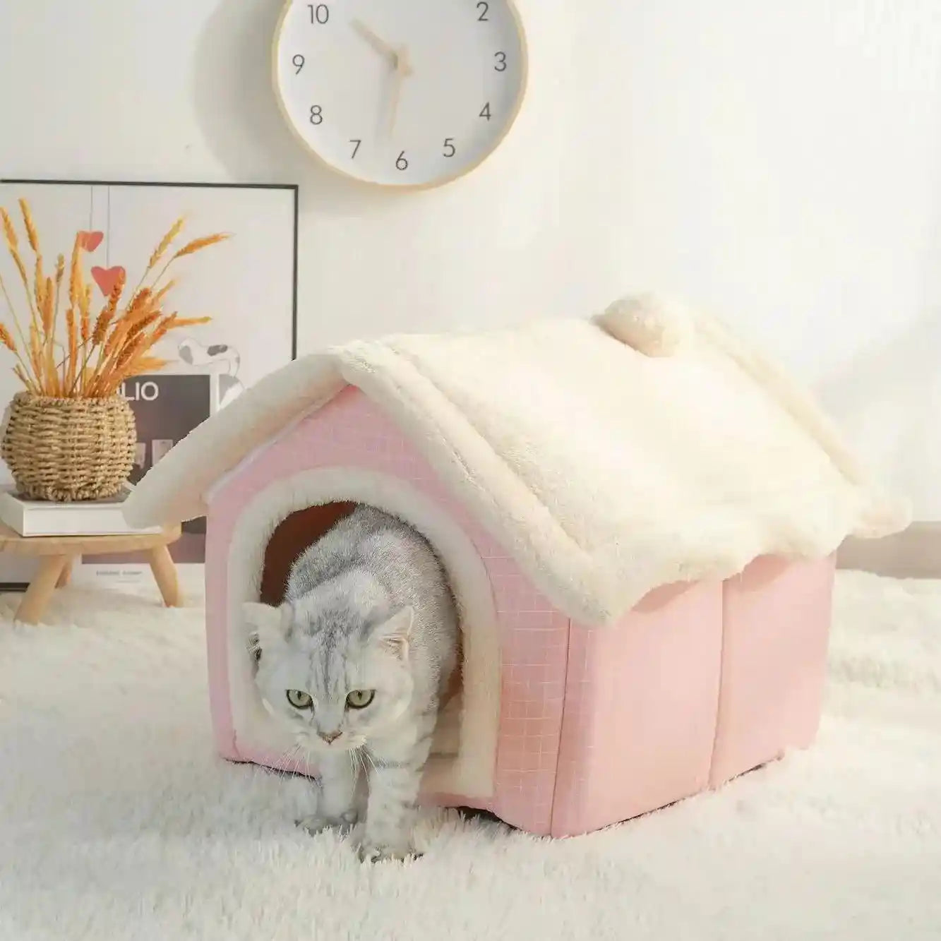 Cat leaving pink soft pet bed with white roof.